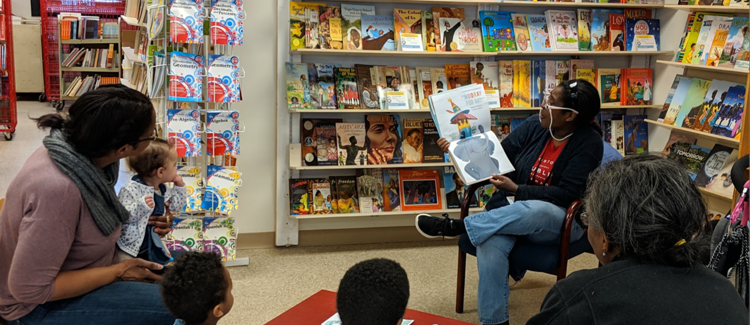 Librarian reading a group of children a book
